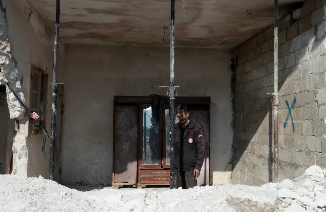Bashir looking at his damaged home.