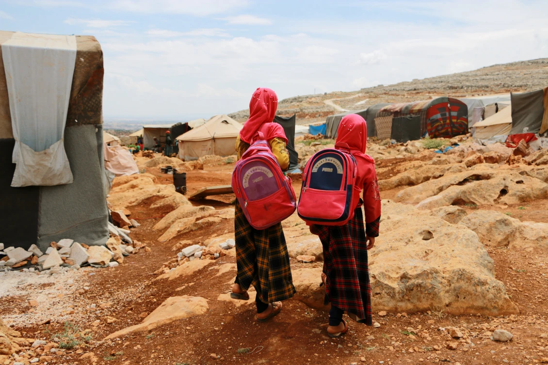Two girls returning home from school, Othmania camp, NWS