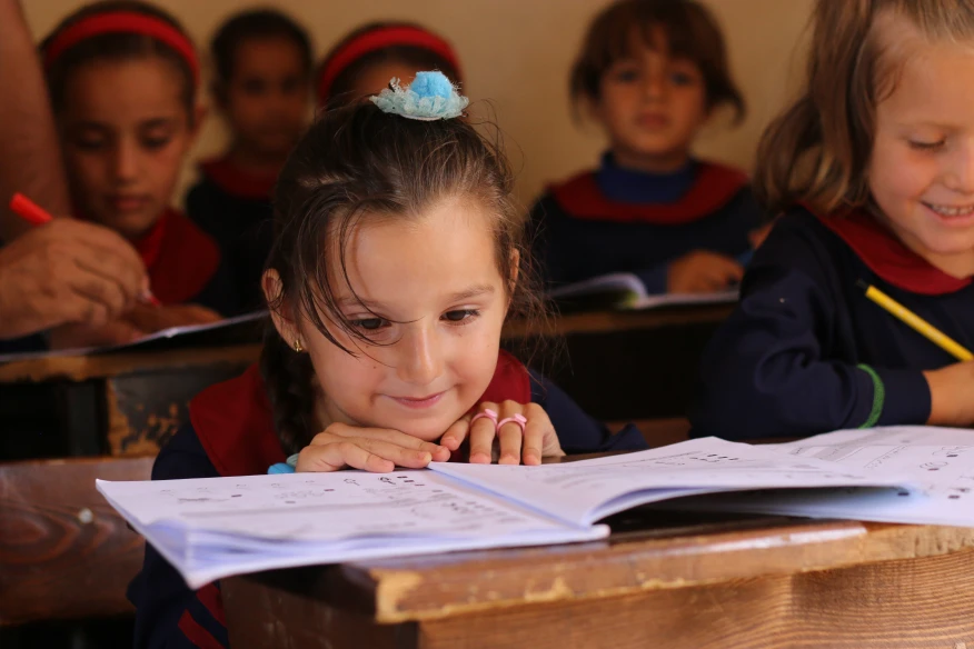 Description: These photos show school students in Idleb governorate in Syria’s northwest receiving school uniform distributed for free. These uniforms were made under a PIN cash for work project generously funded by Swiss Agency for Development and Cooperation (SDC) and were distributed in the twelve schools also funded by SDC. Besides providing work opportunities for tens of women, mostly displaced, the activity increases the sense of equality among the children as they all put on the same type of clothing. Note: Please do not publish the author’s name and contact PIN Syria Communications before publishing. (Donor SDC)