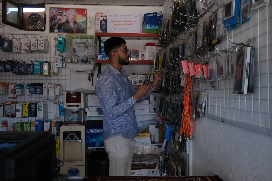 Mohammad working in a mobile shop in Basirma Camp, Kurdistan Iraq. 