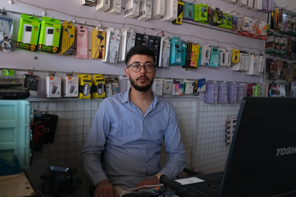 Mohammad sitting in the mobile shop he works at in Basirma Camp, Kurdistan Iraq. 